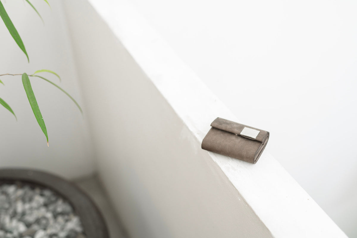 A Bluno leather wallet beside a white wall in natural light