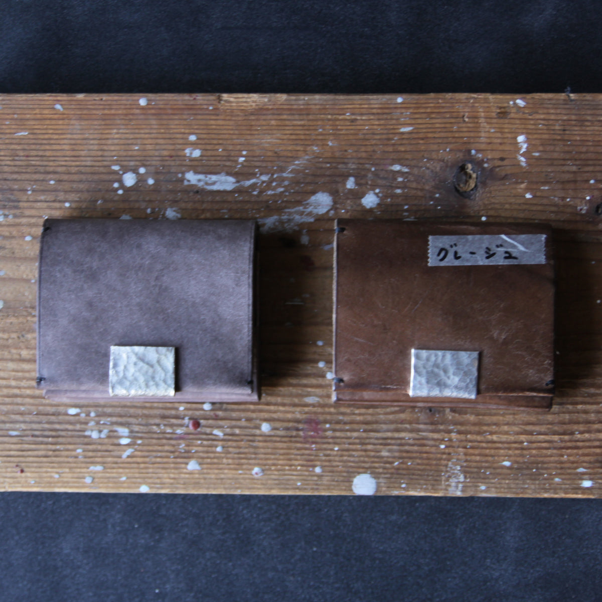 A greige wallet with tin details. Unused on the left; used for three years on the right.